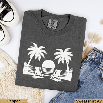 Dark grey t-shirt with white palm trees, beach chairs, and ocean graphic.