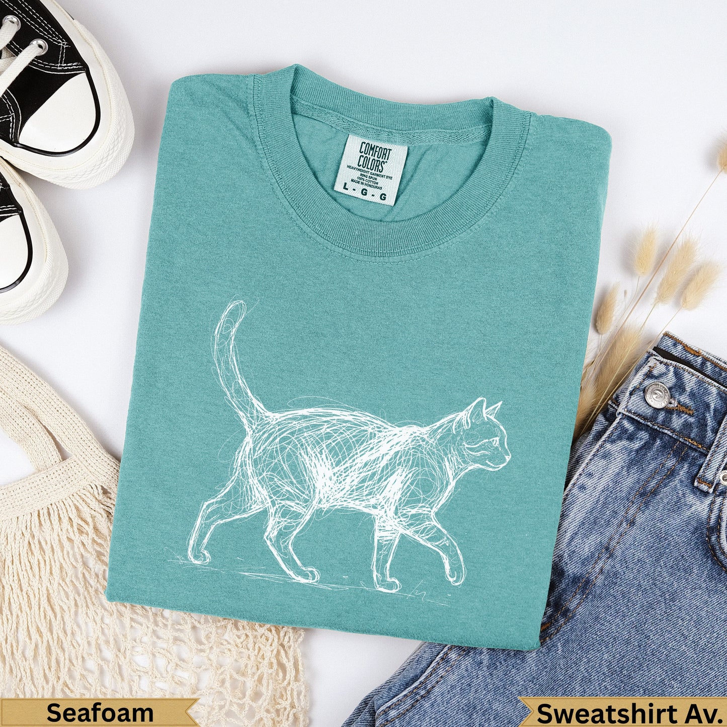Teal t-shirt with a white sketch of a cat, "Seafoam" and "Sweatshirt Av." labels.