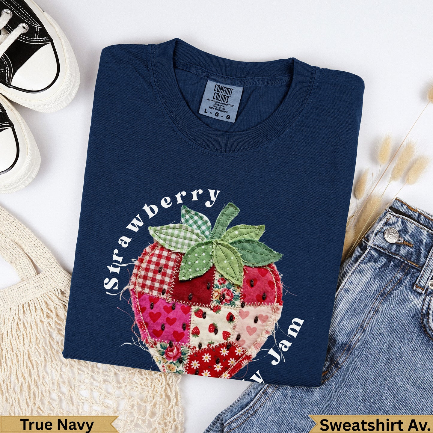 Navy blue sweatshirt with a patchwork strawberry design and "Strawberry Jam" text.