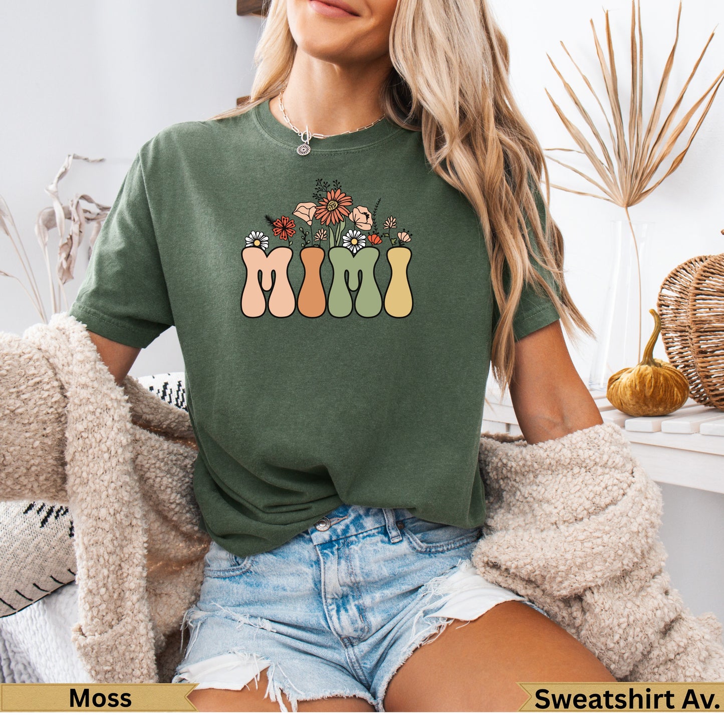 Green t-shirt with "MIMI" text design featuring flowers in pastel colors.