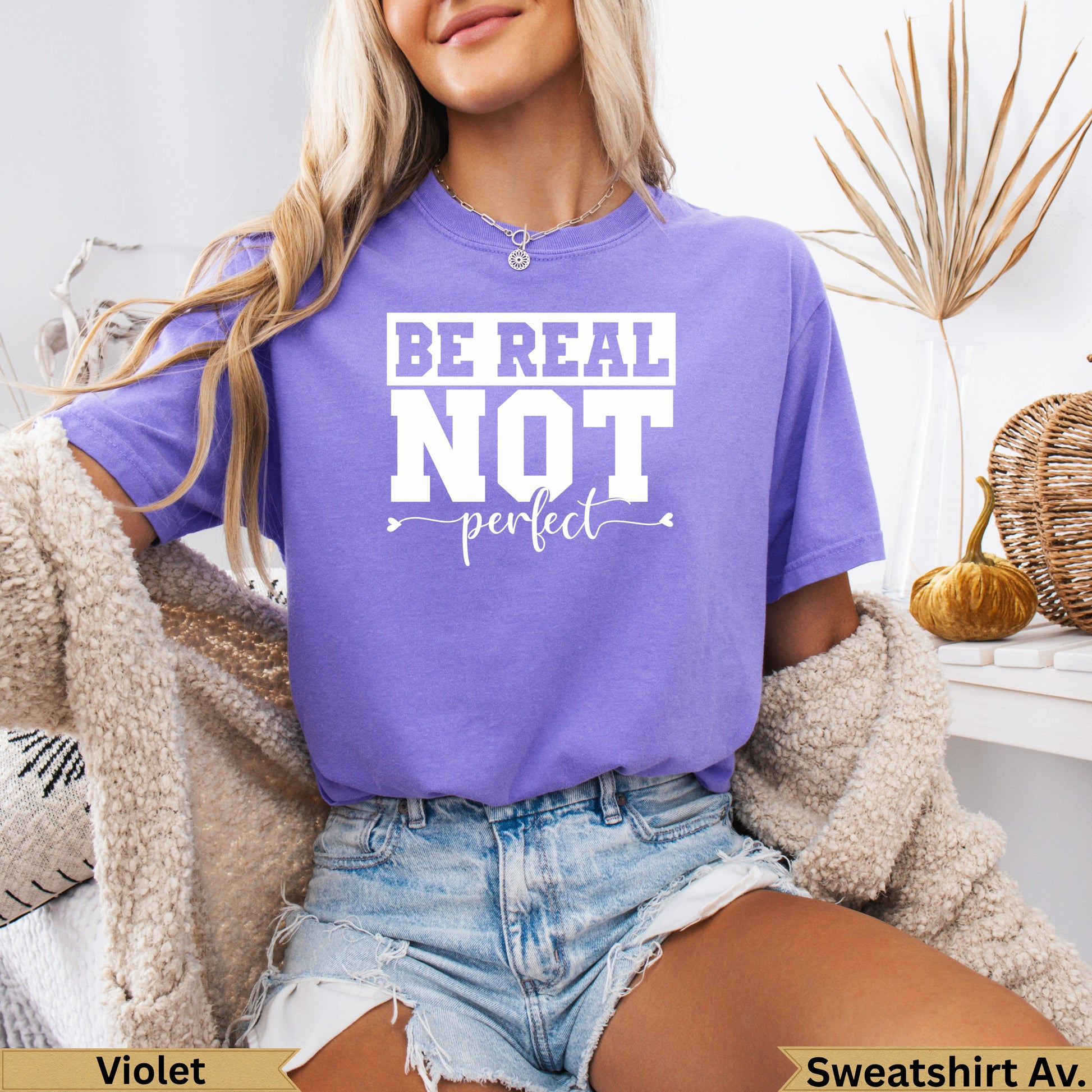T-shirt with "BE REAL not perfect" text in white on a purple background.