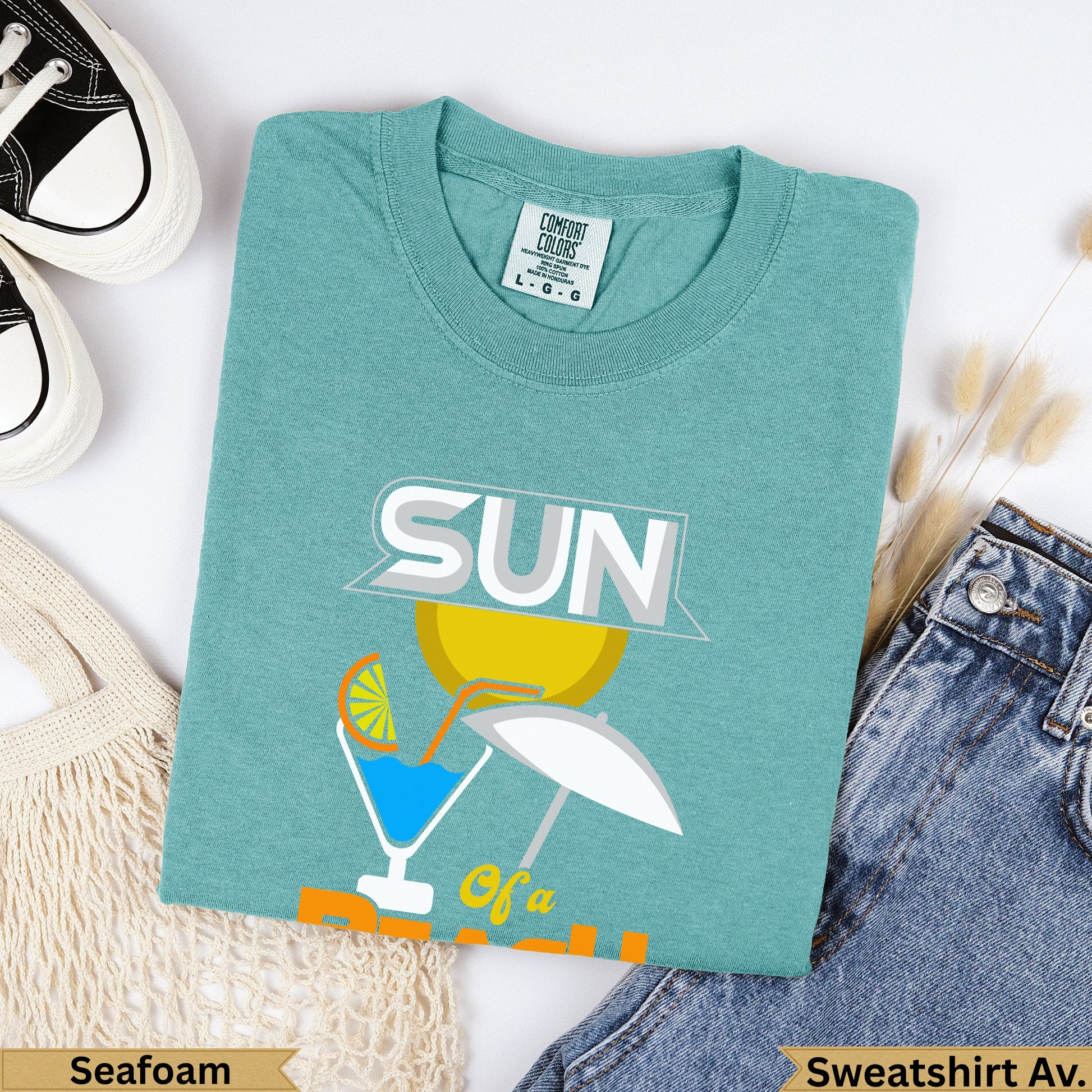 Seafoam Comfort Colors sweatshirt with "SUN of a" graphic and small umbrella.