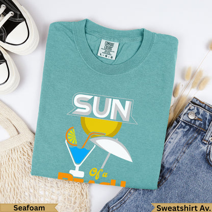 Seafoam Comfort Colors sweatshirt with "SUN of a" graphic and small umbrella.