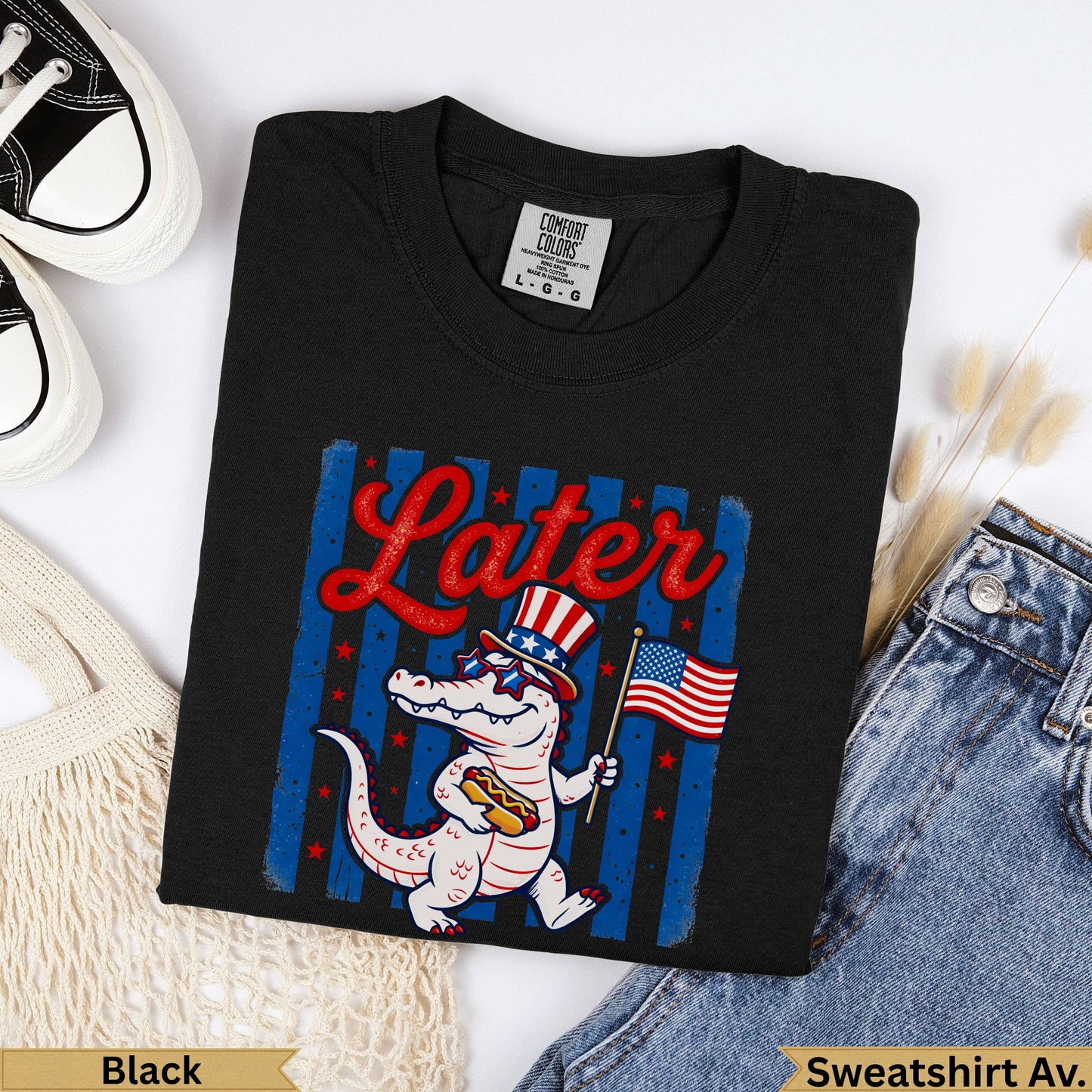 Black t-shirt with cartoon alligator holding American flag and hot dog, text "Later".