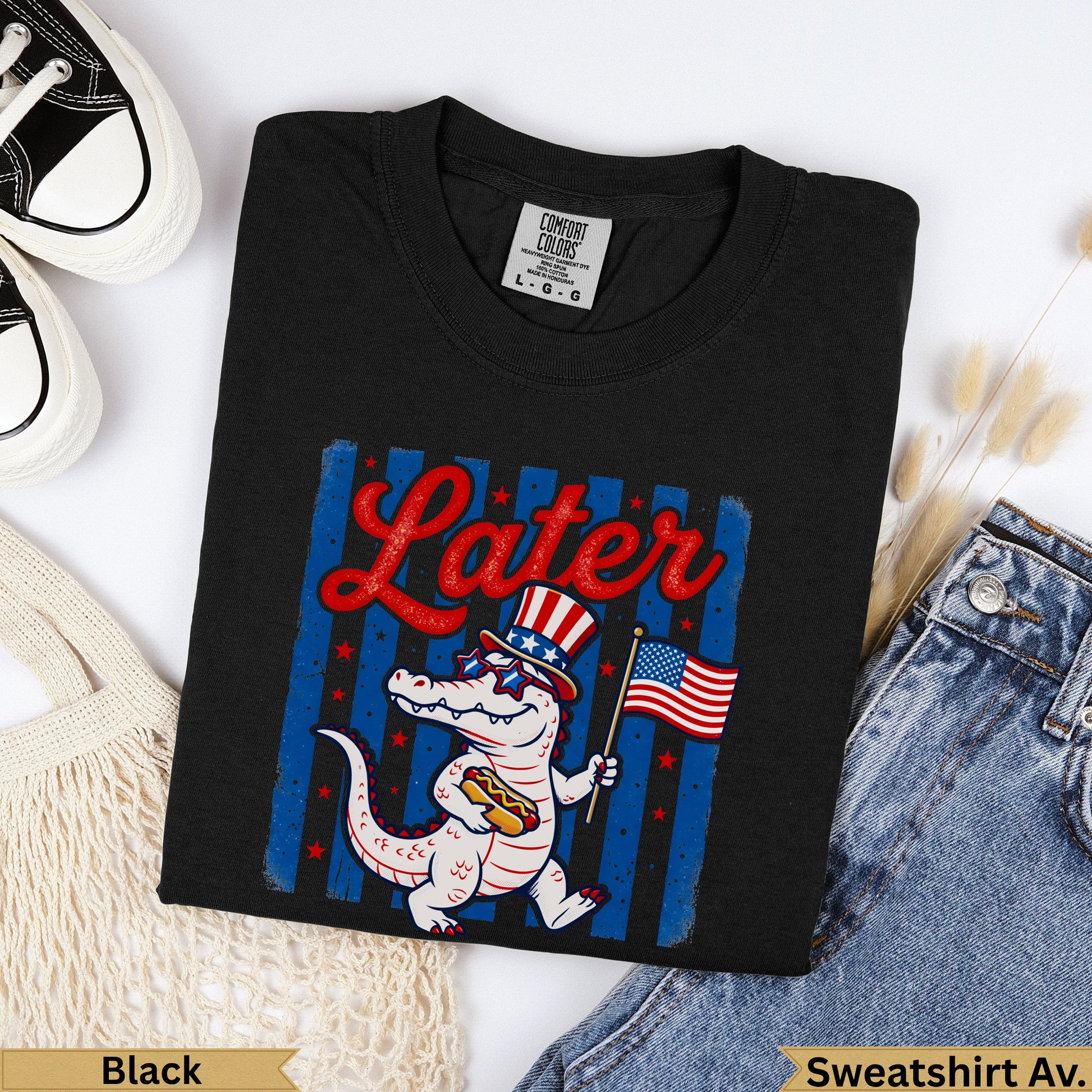 Black t-shirt with cartoon alligator holding American flag and hot dog, text "Later".