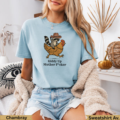 Light blue t-shirt with raccoon riding chicken graphic and "Giddy Up Mother F*cker" text.