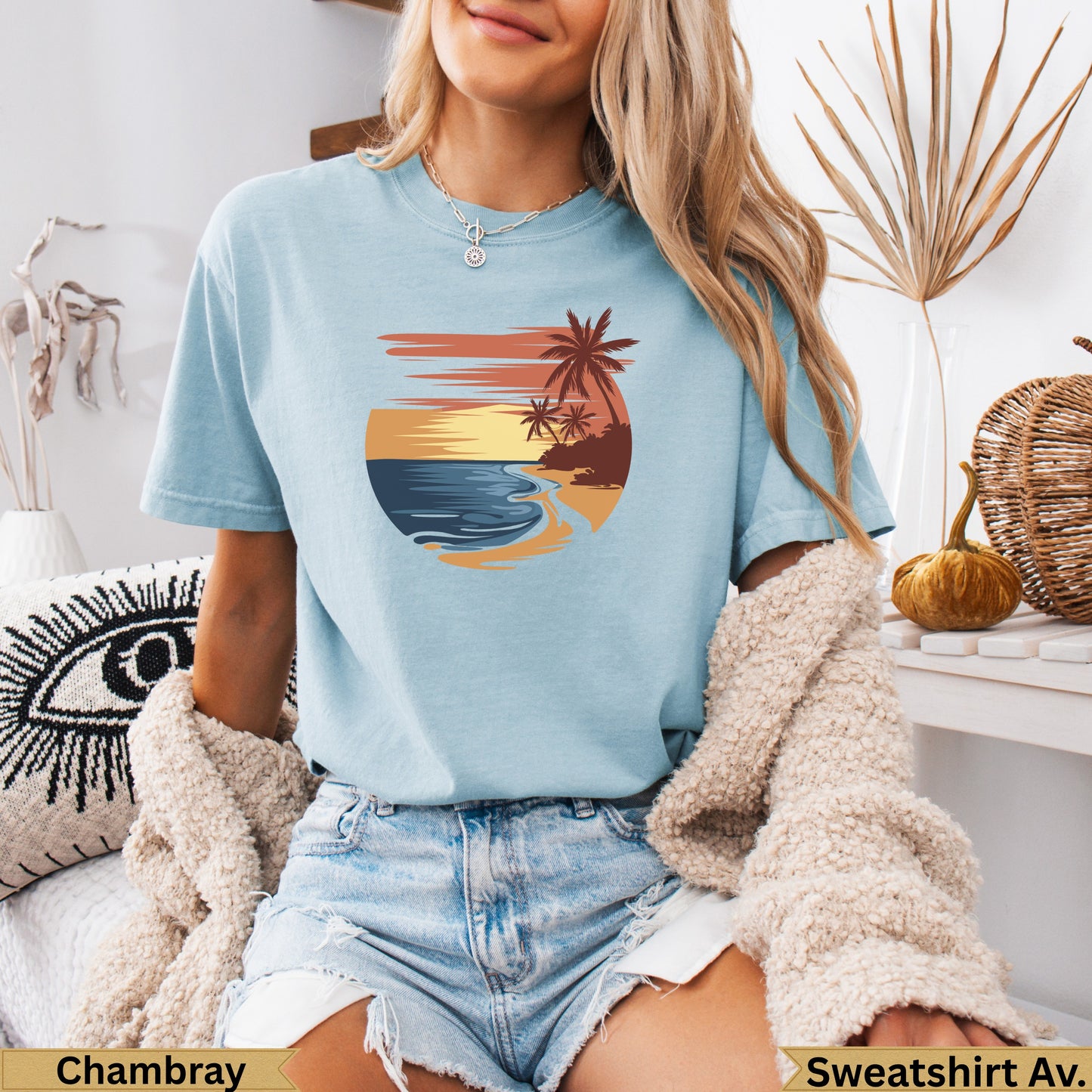 Light blue t-shirt with sunset beach graphic and palm trees.