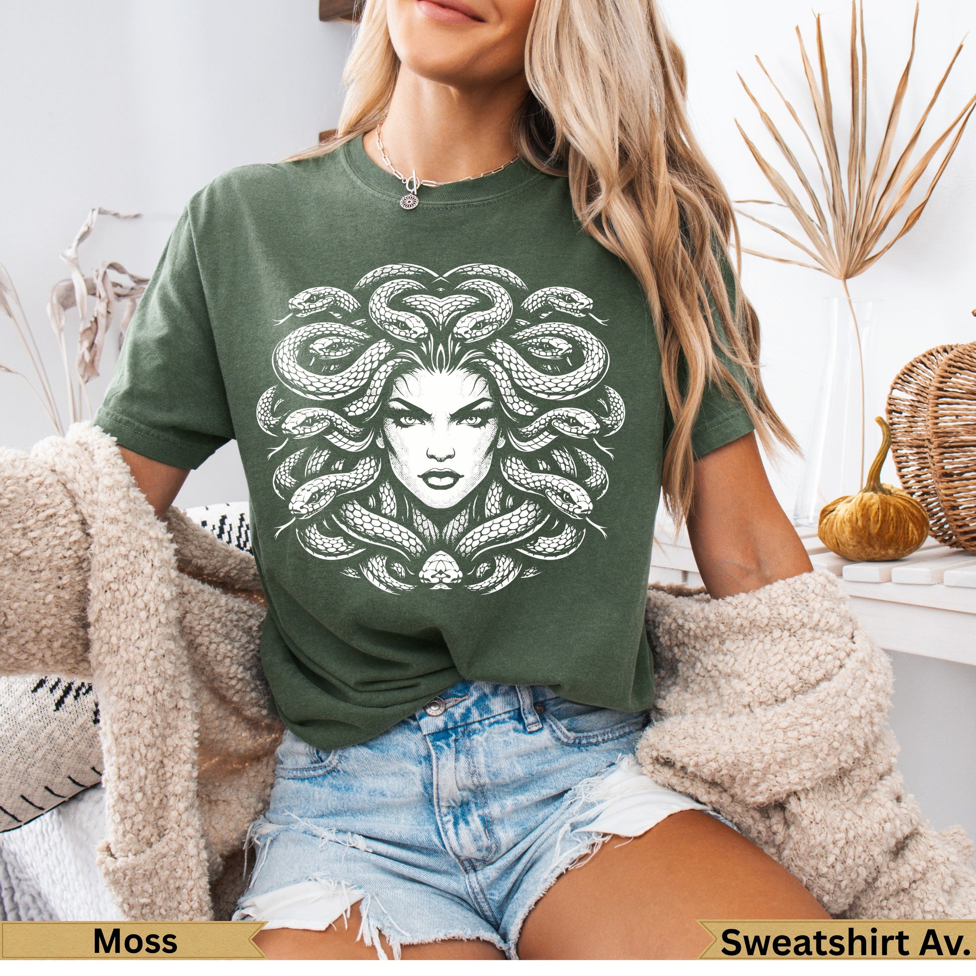 Green t-shirt with white Medusa graphic on the front.