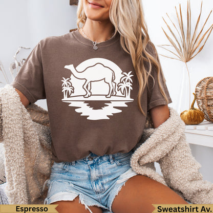 Brown t-shirt with a white graphic of a camel, palm trees, and sunset.