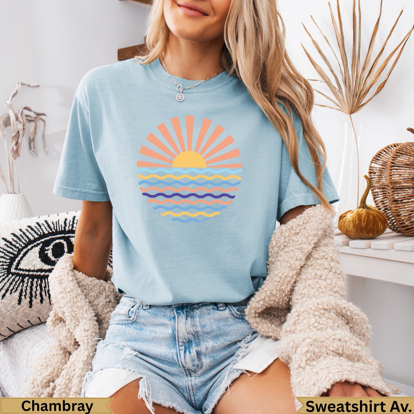 Light blue t-shirt with a graphic of a sun over wavy water.