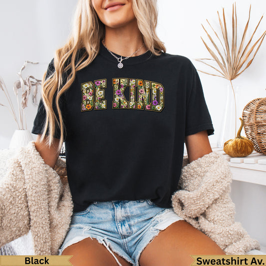 Black t-shirt with "BE KIND" floral lettering, worn by a woman.