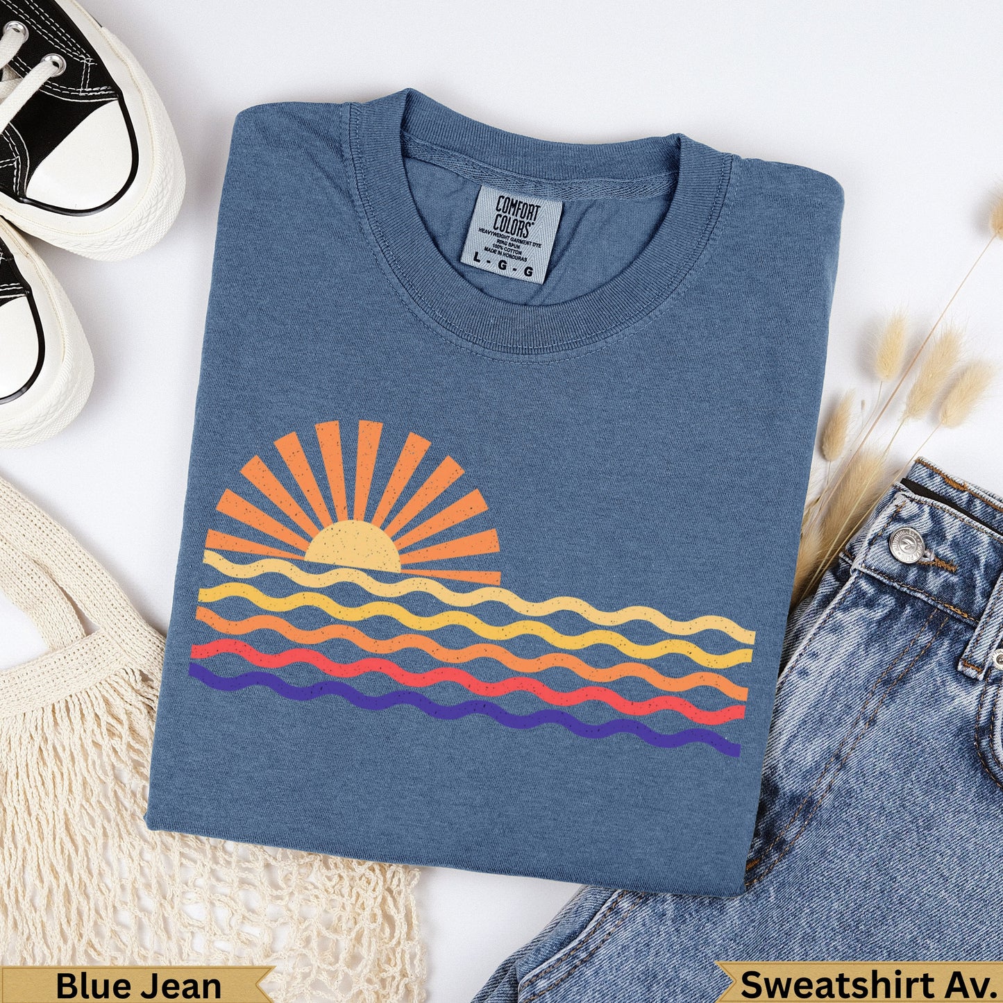 Blue Jean Comfort Colors sweatshirt with a colorful sunset and wavy ocean graphic.