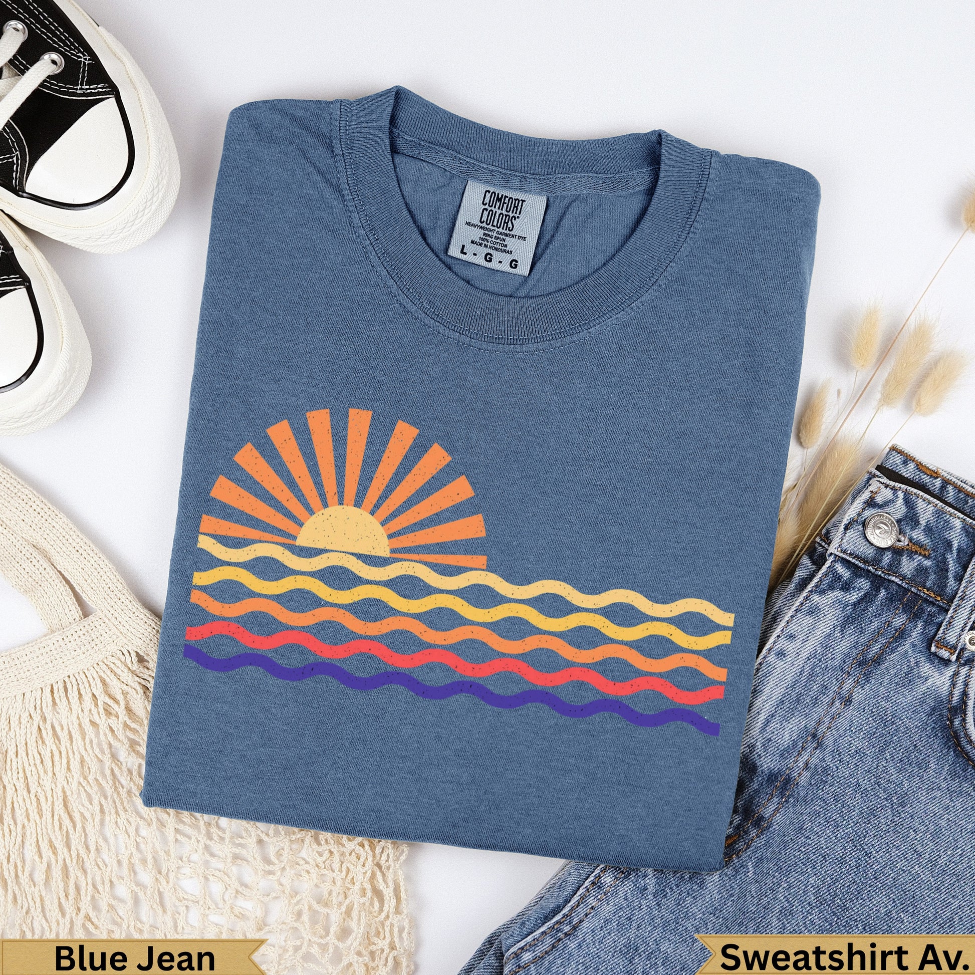 Blue Jean Comfort Colors sweatshirt with a colorful sunset and wavy ocean graphic.