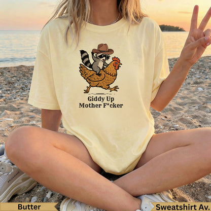 Raccoon and chicken graphic with "Giddy Up Mother F*cker" text on a yellow t-shirt.