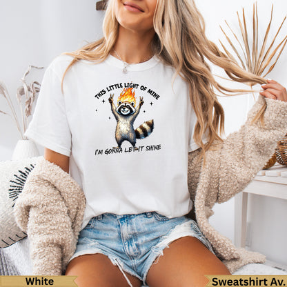 Raccoon on a white t-shirt with "THIS LITTLE LIGHT OF MINE I'M GONNA LET IT SHINE" text.