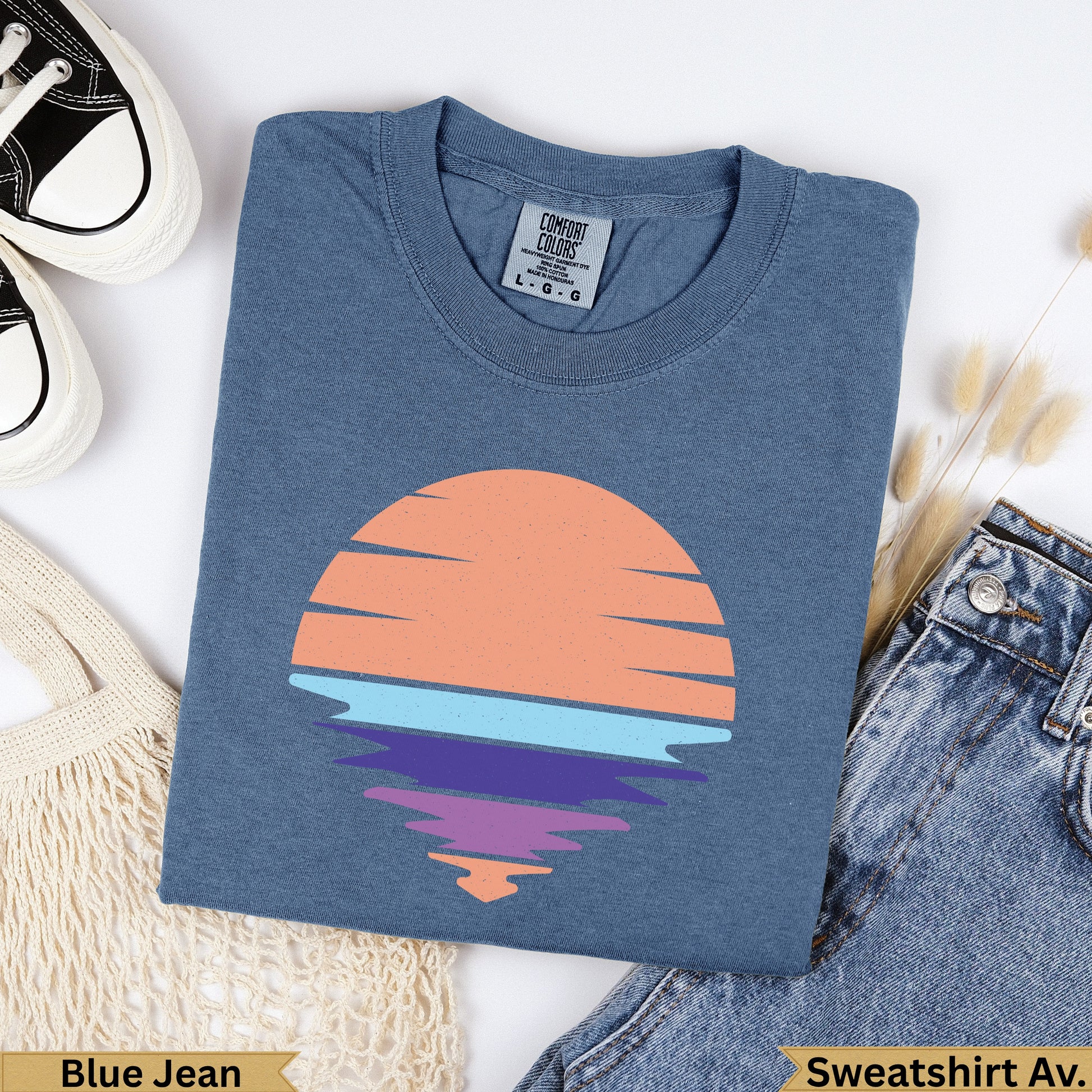 Blue Jean Comfort Colors sweatshirt with a sunset graphic over water.