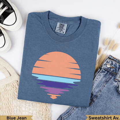 Blue Jean Comfort Colors sweatshirt with a sunset graphic over water.