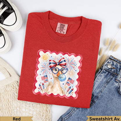 Red t-shirt with a cartoon duck wearing glasses, blowing bubbles, with fireworks and flags.