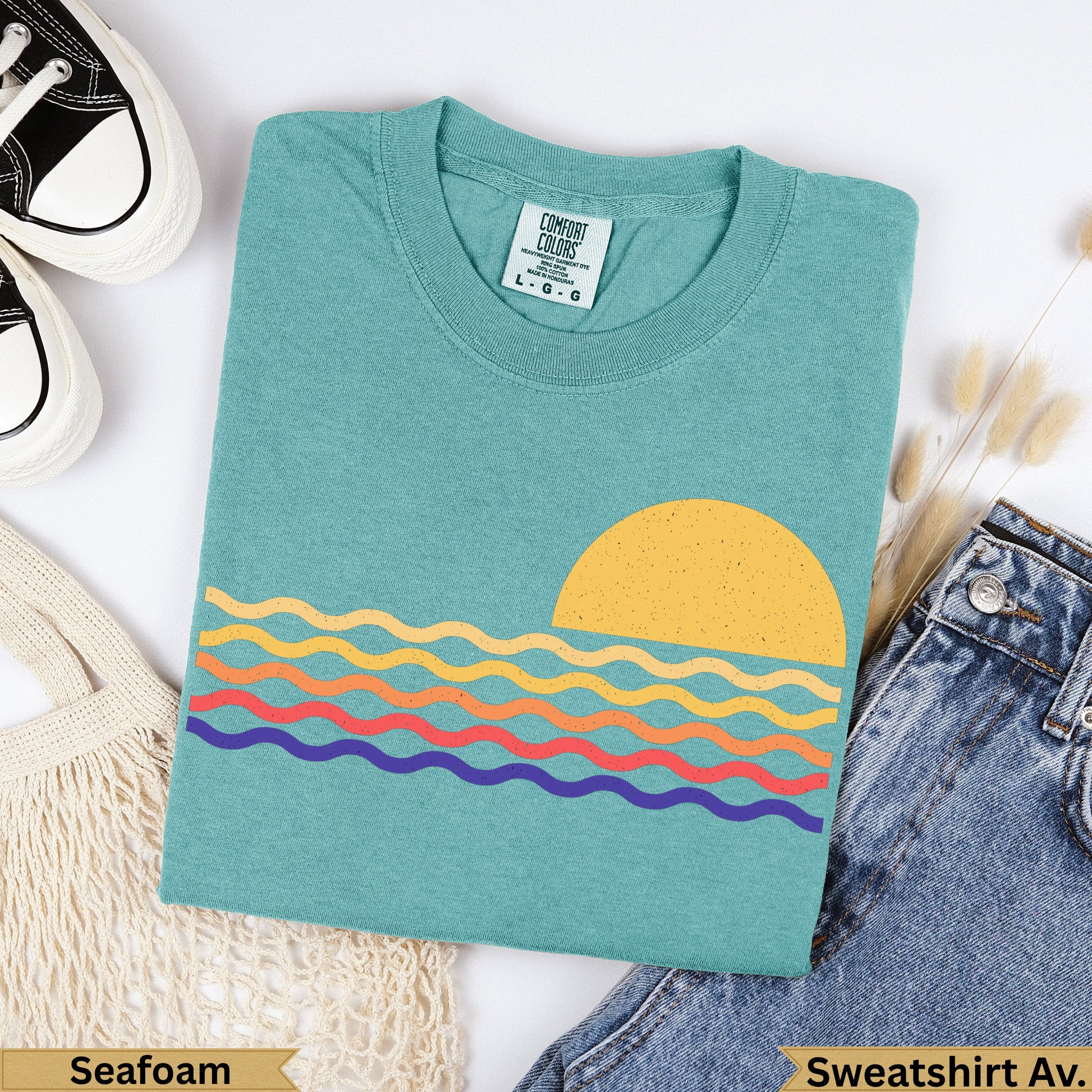Teal t-shirt with colorful wavy lines and a sun graphic, "Seafoam" text.