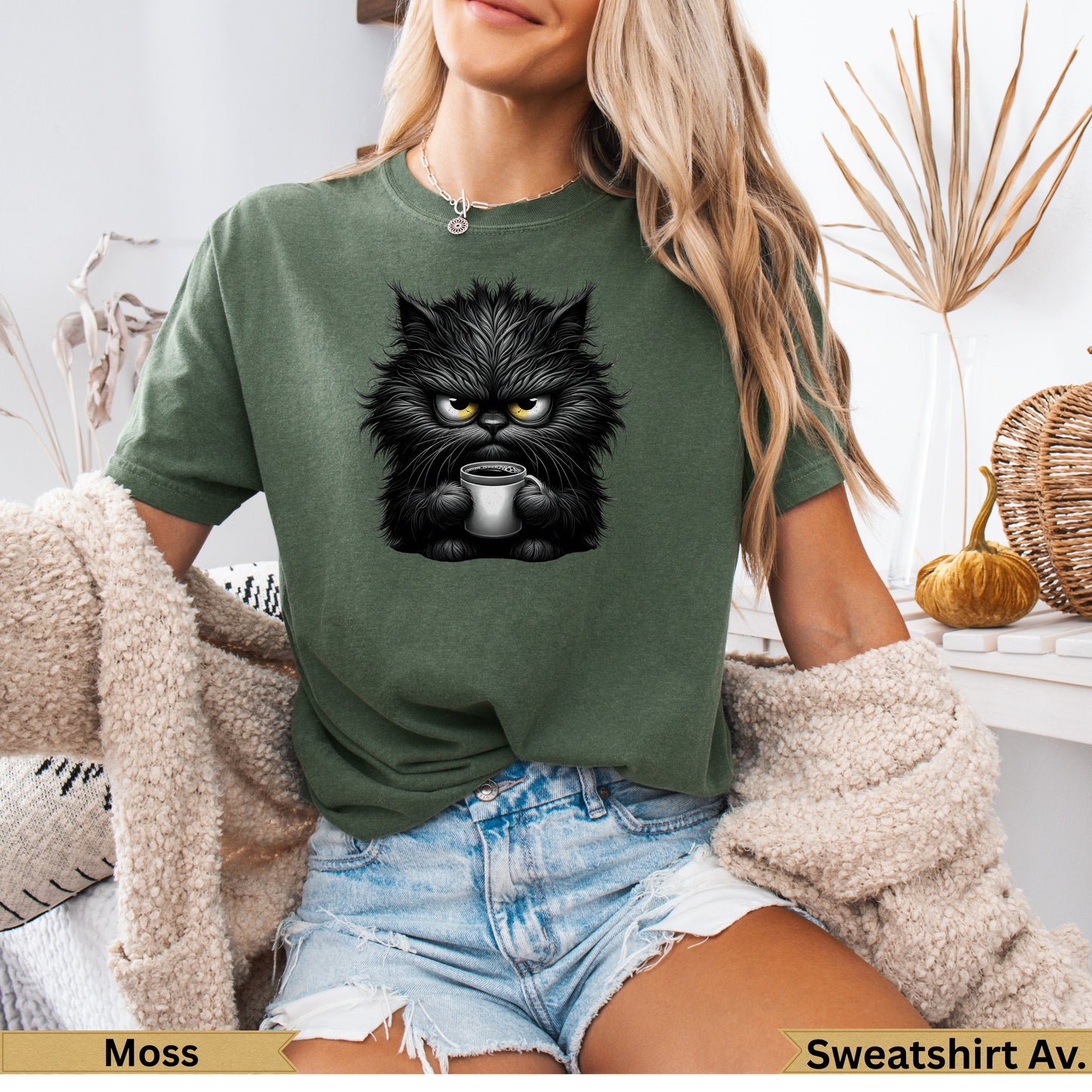 Green t-shirt featuring a grumpy black cat holding a coffee cup.