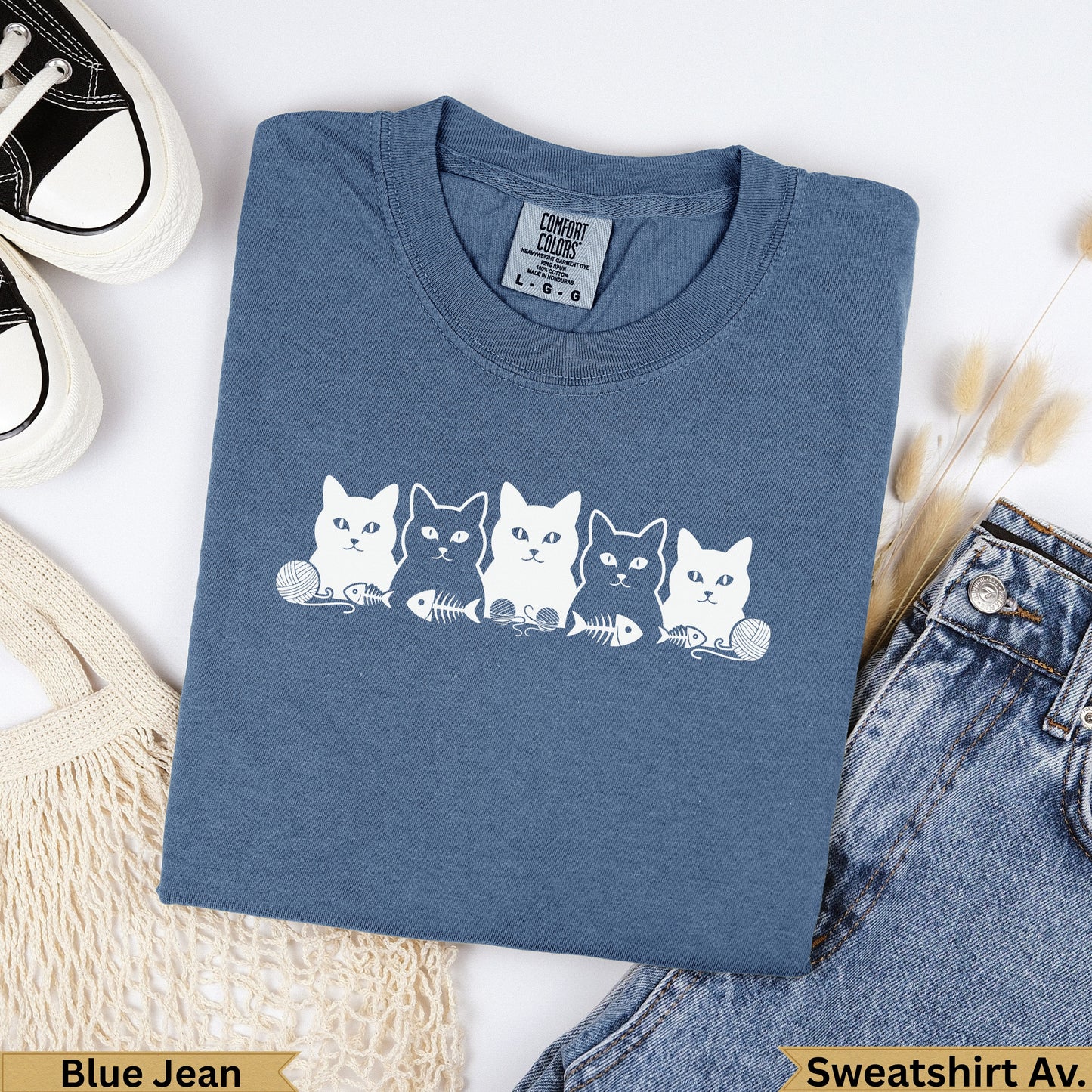 Blue sweatshirt with a row of five white cats and fish skeleton designs.