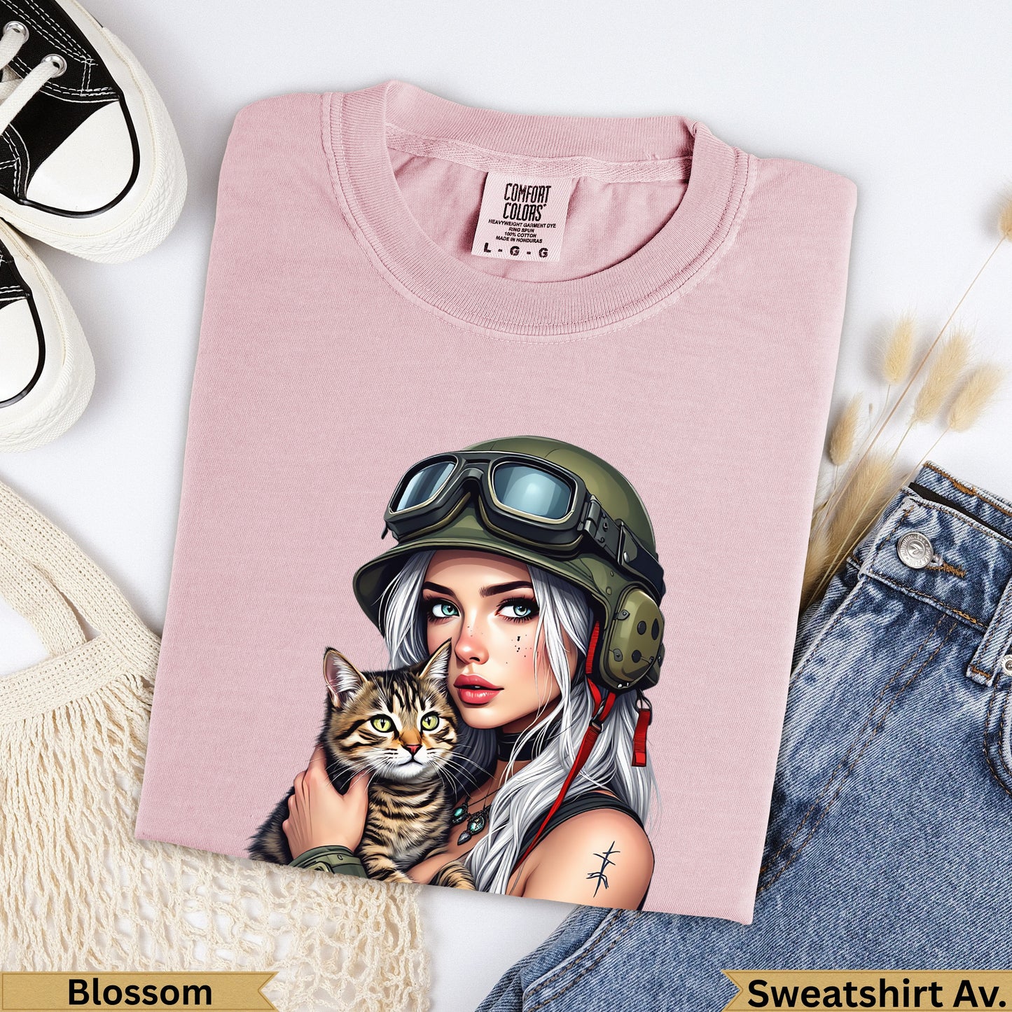 Pink t-shirt with woman in goggles holding cat, "Blossom" and "Sweatshirt Av." text.