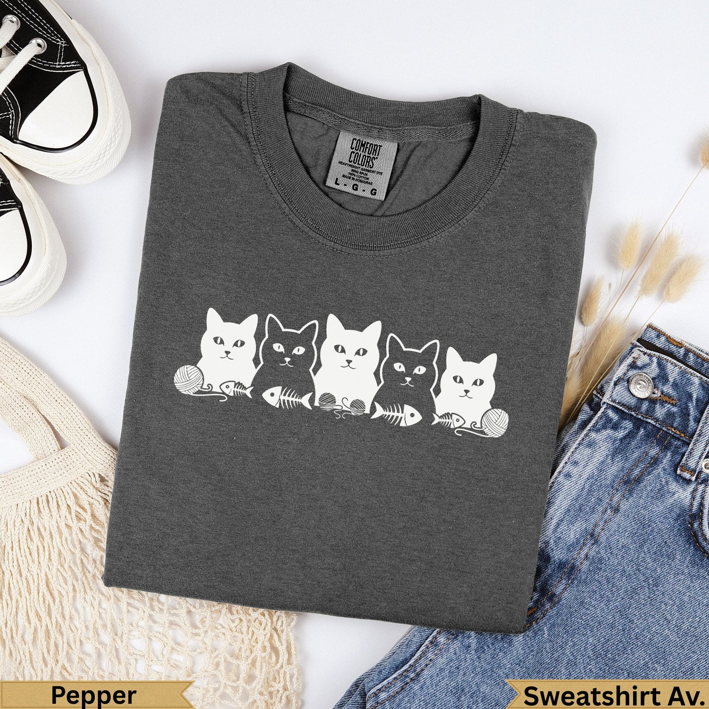 Dark grey sweatshirt with five white cartoon cats, yarn, and fish skeletons.