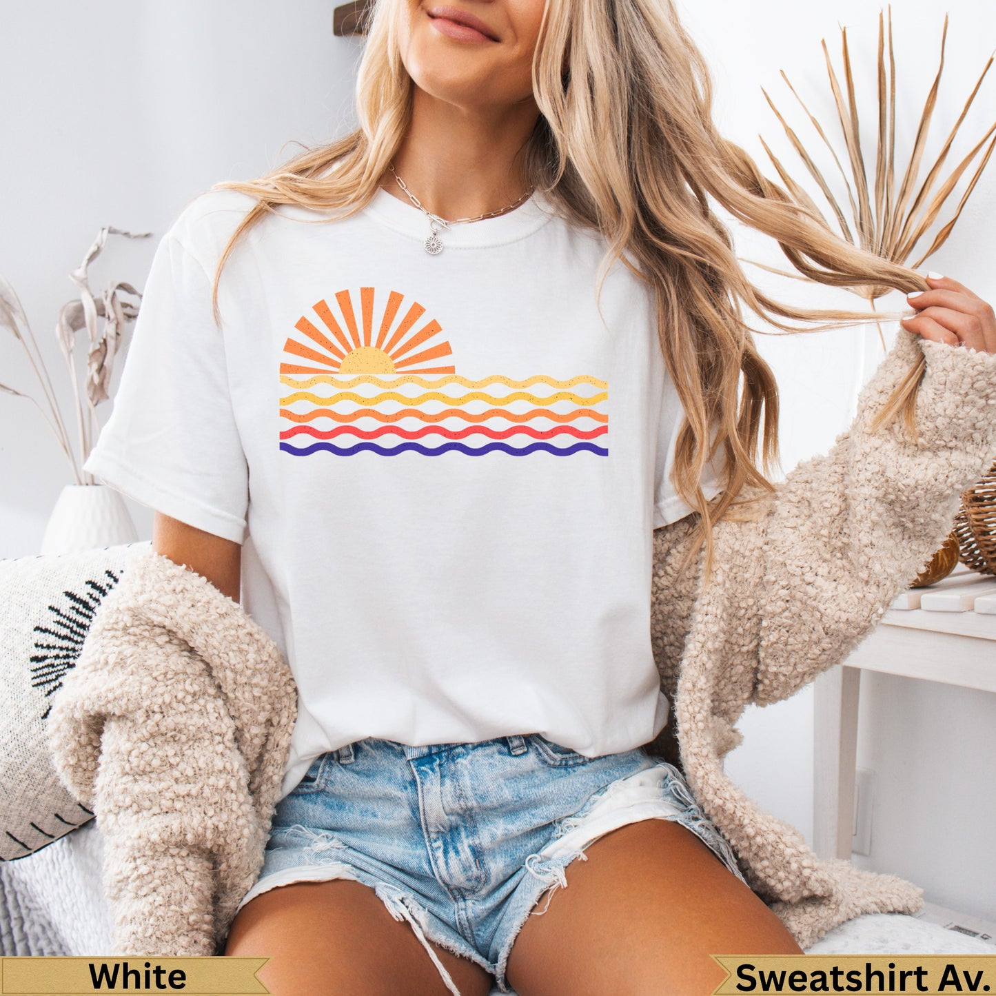 White t-shirt with a colorful retro sunset and wavy lines graphic.