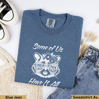 Blue jean graphic t-shirt with raccoon wearing sunglasses and text "Some of Us Kinda Classy Kinda Trashy Have It All".