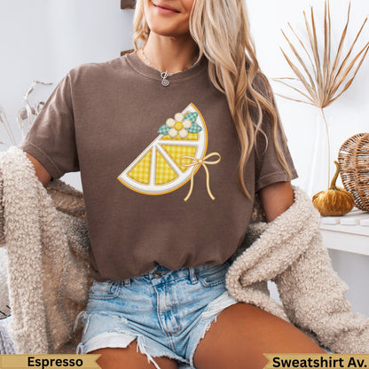 Brown graphic t-shirt with a yellow lemon slice design featuring a blue gingham ribbon.