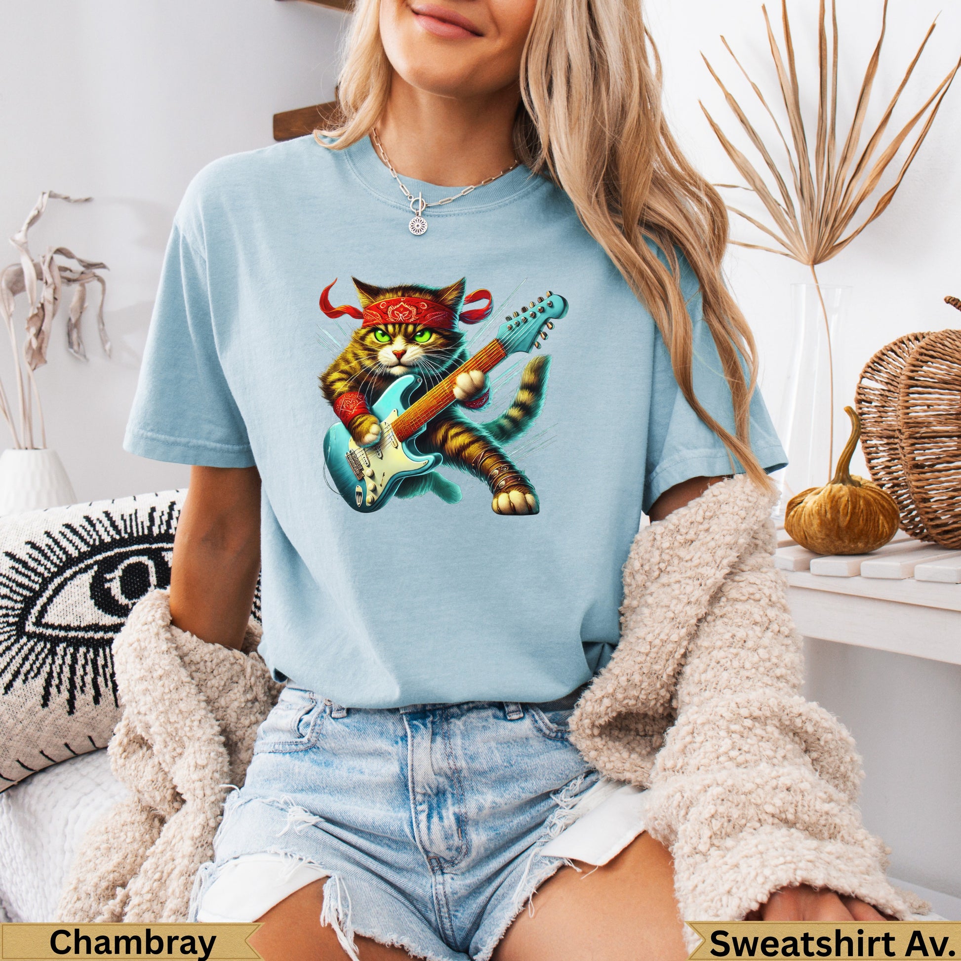 Blue t-shirt with a cartoon cat playing a red electric guitar, wearing a red bandana.