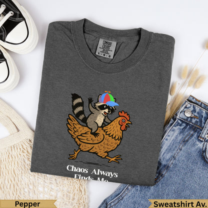 Dark gray Comfort Colors t-shirt with raccoon riding chicken graphic and text.