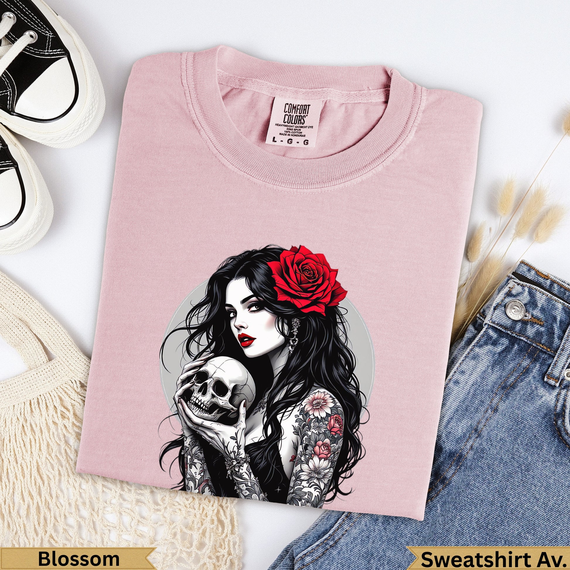 Pink t-shirt with woman holding skull and rose tattoo art.