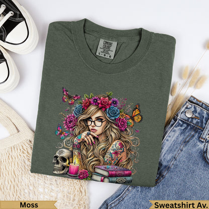 Olive green t-shirt with woman and floral crown artwork, skull, and books.
