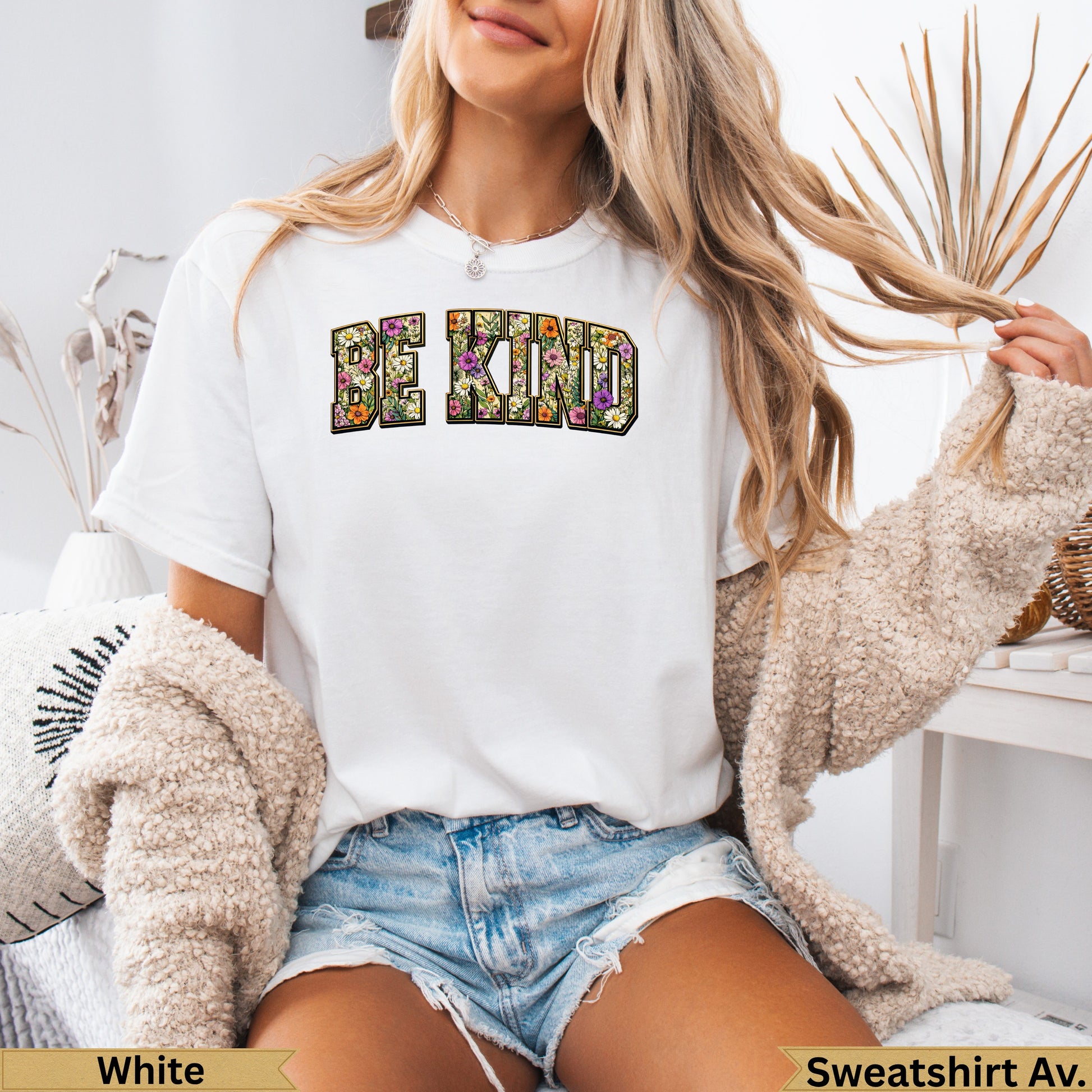 White crewneck t-shirt with "BE KIND" text filled with floral pattern.