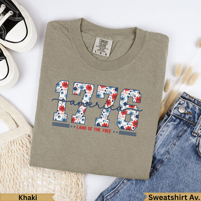 Khaki sweatshirt with "1776 Land of the Free" graphic in red and blue floral letters.