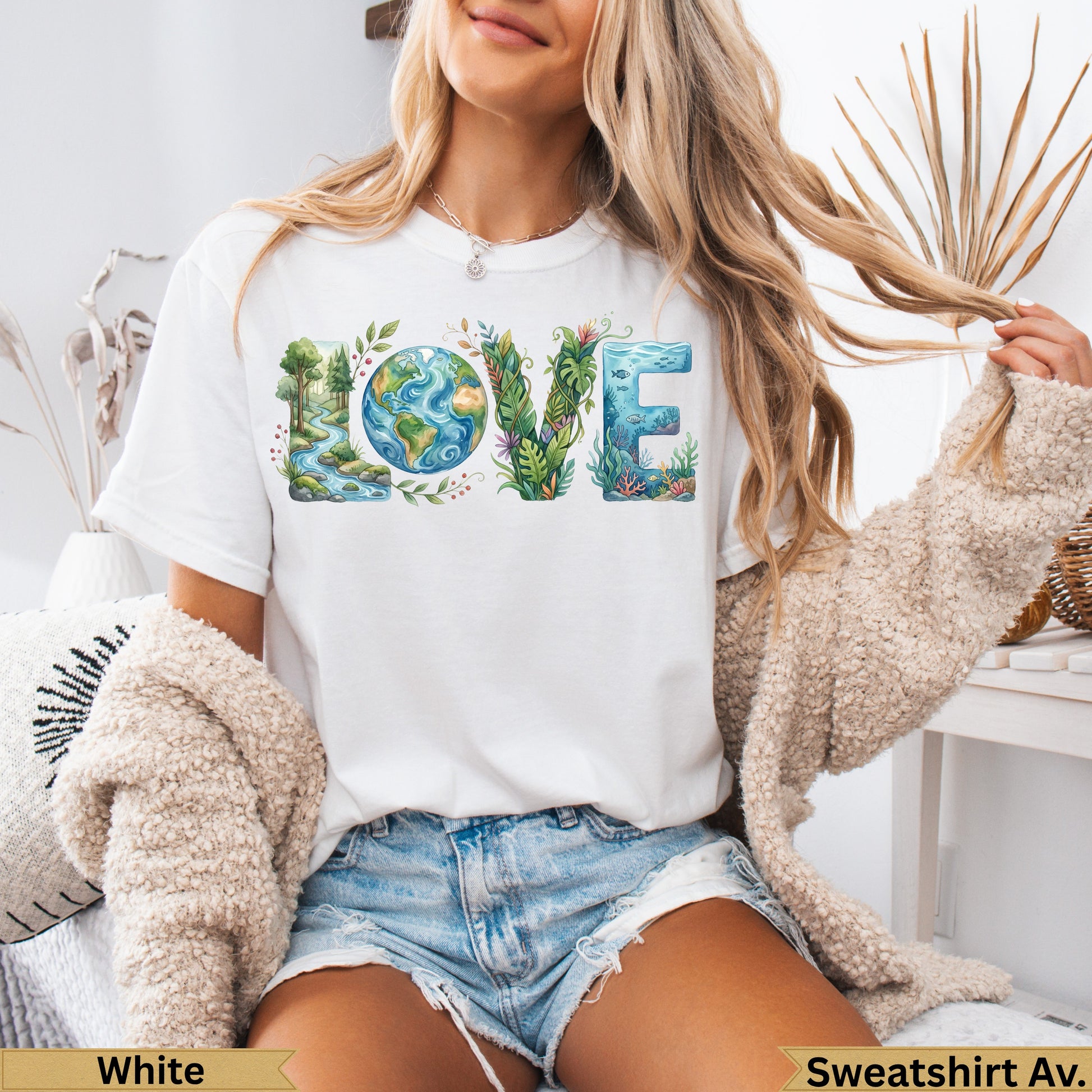 White t-shirt with "LOVE" in nature-themed letters, model wearing denim shorts.