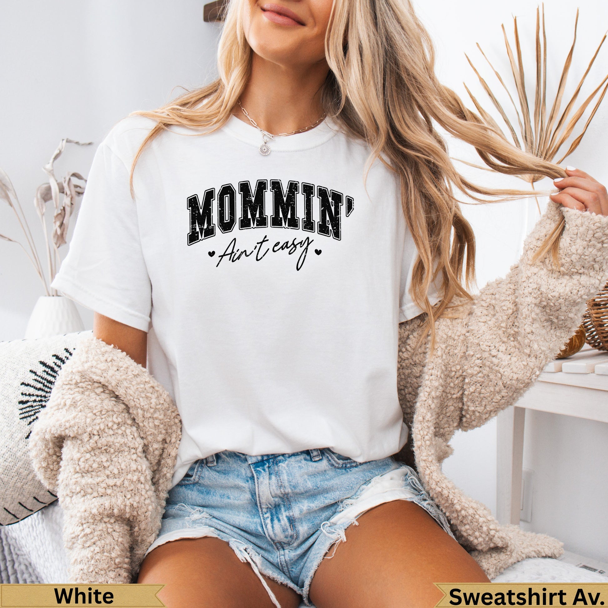 White t-shirt with "MOMMIN' Ain't easy" text and heart accents.