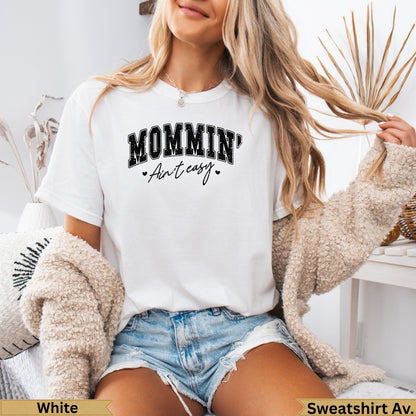 White t-shirt with "MOMMIN' Ain't easy" text and heart accents.