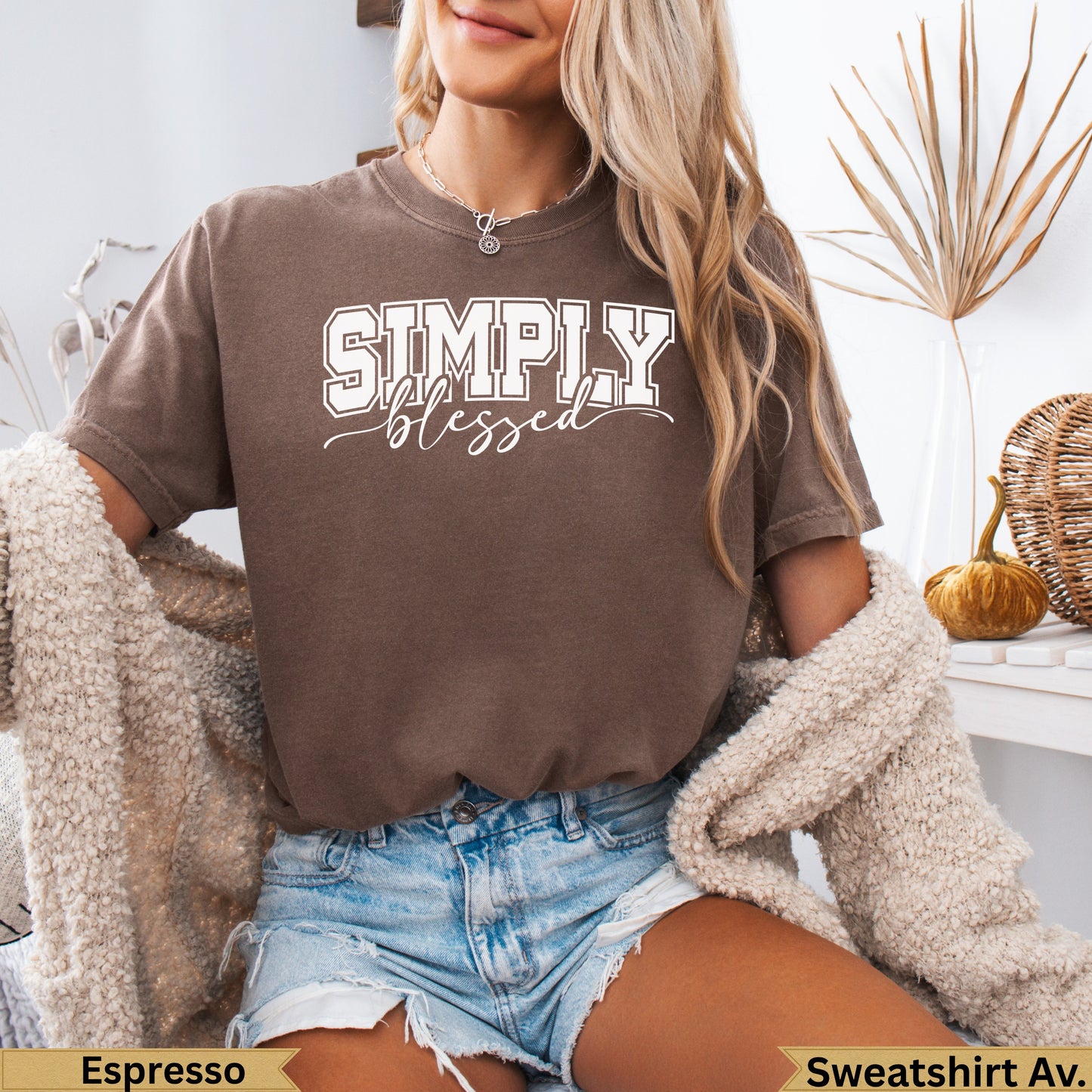 Woman wearing a brown "SIMPLY blessed" graphic t-shirt and denim shorts.