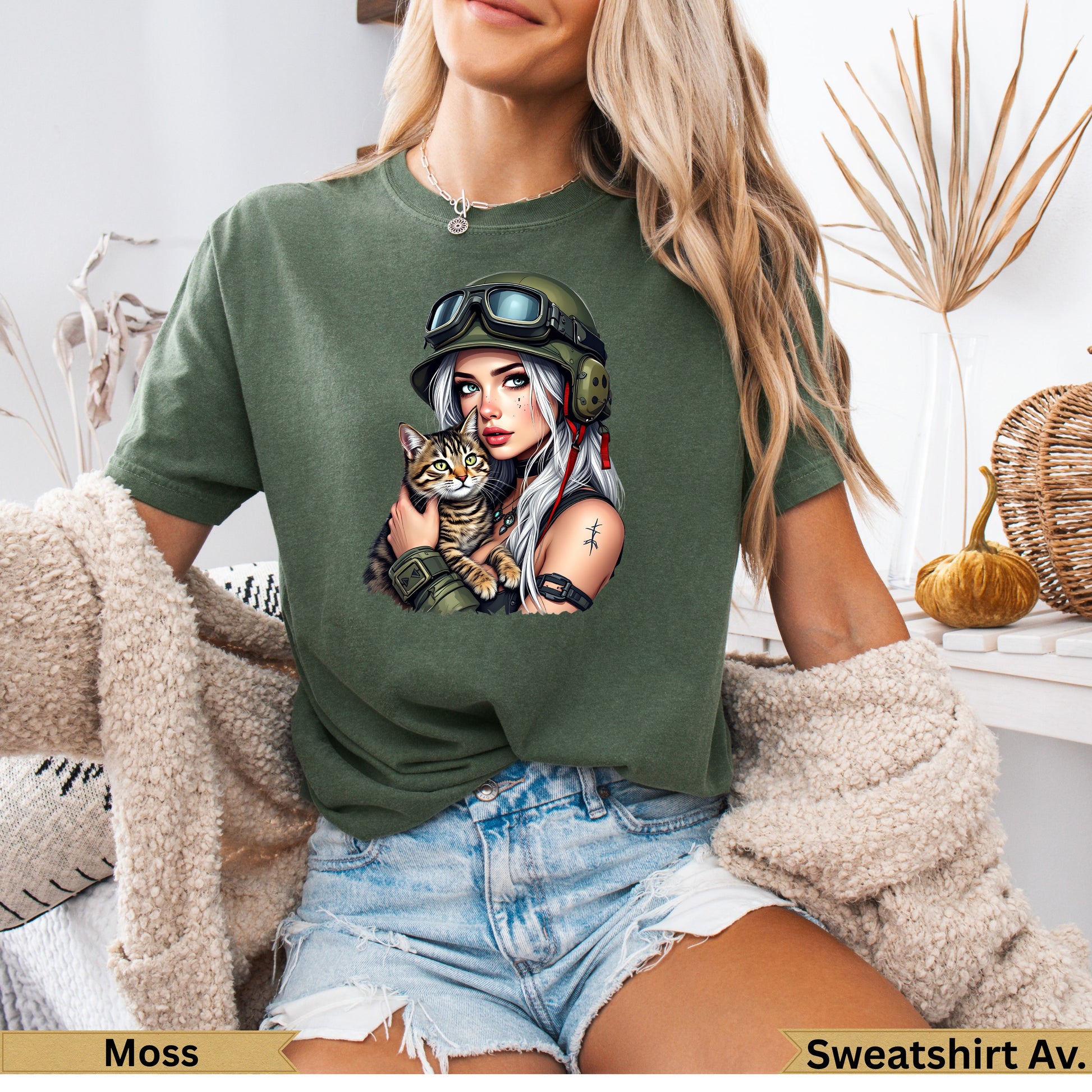 Woman in olive green t-shirt holding a cat, wearing a military helmet.
