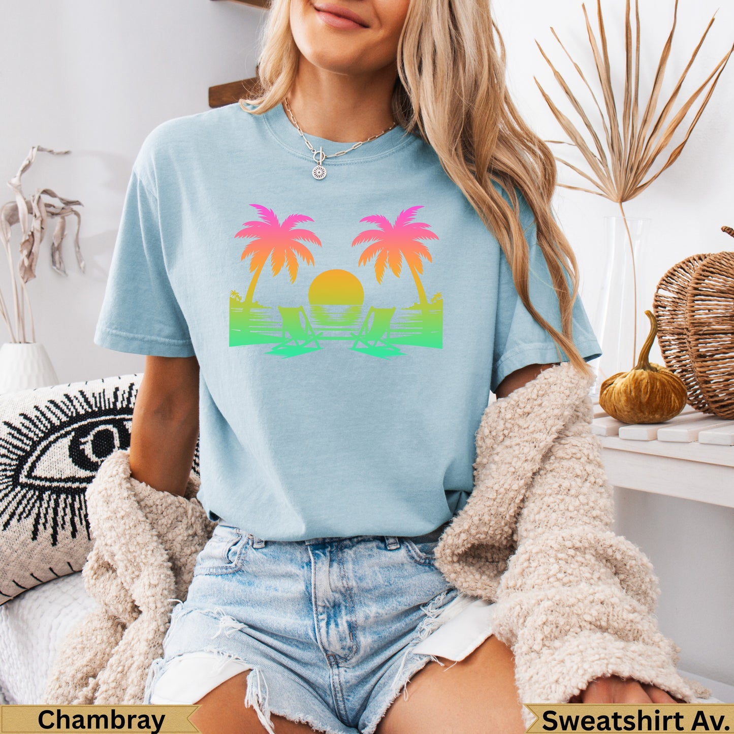 Light blue t-shirt with palm trees, beach chairs, and sunset graphic.