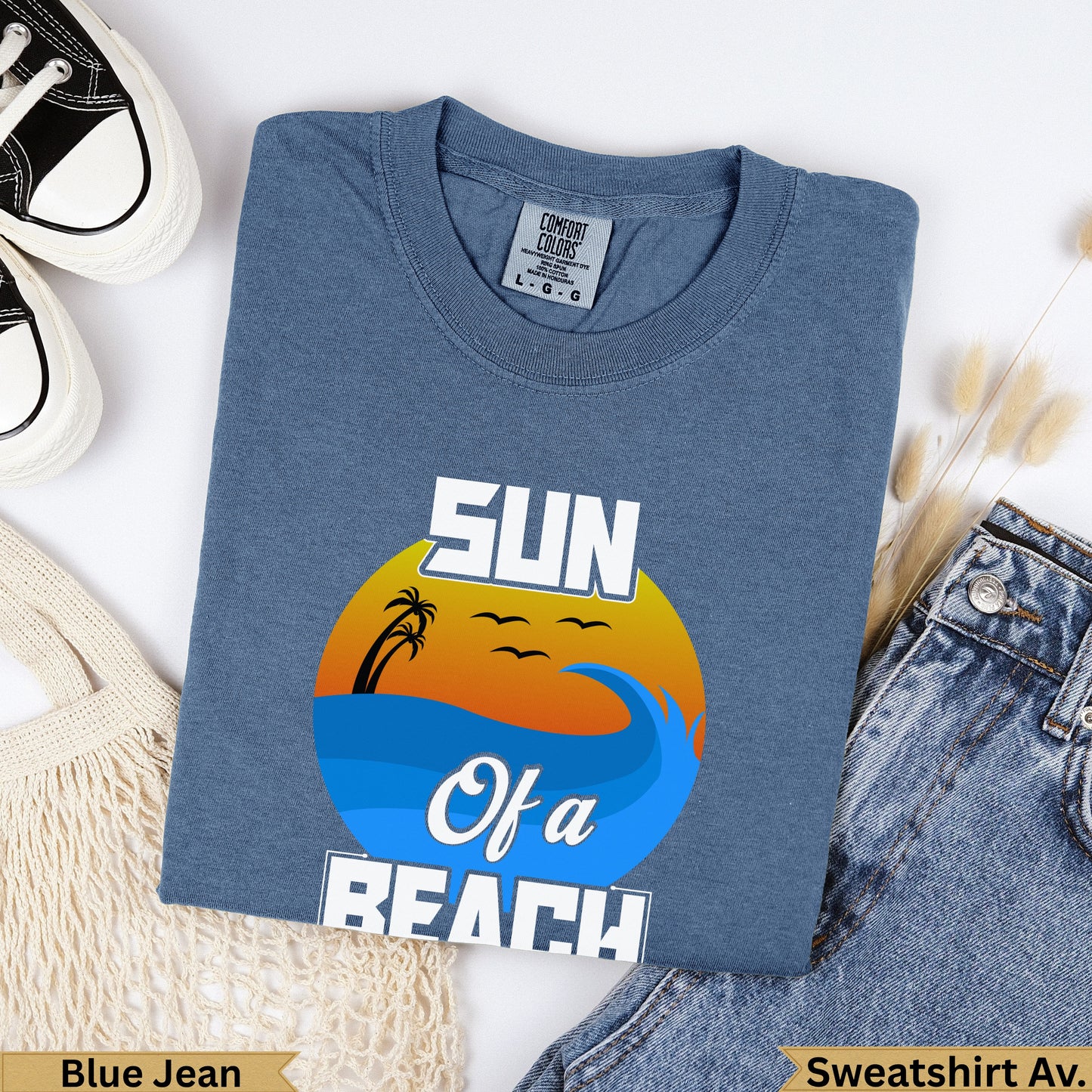 Blue t-shirt with "SUN Of a BEACH" graphic featuring a sunset over waves.