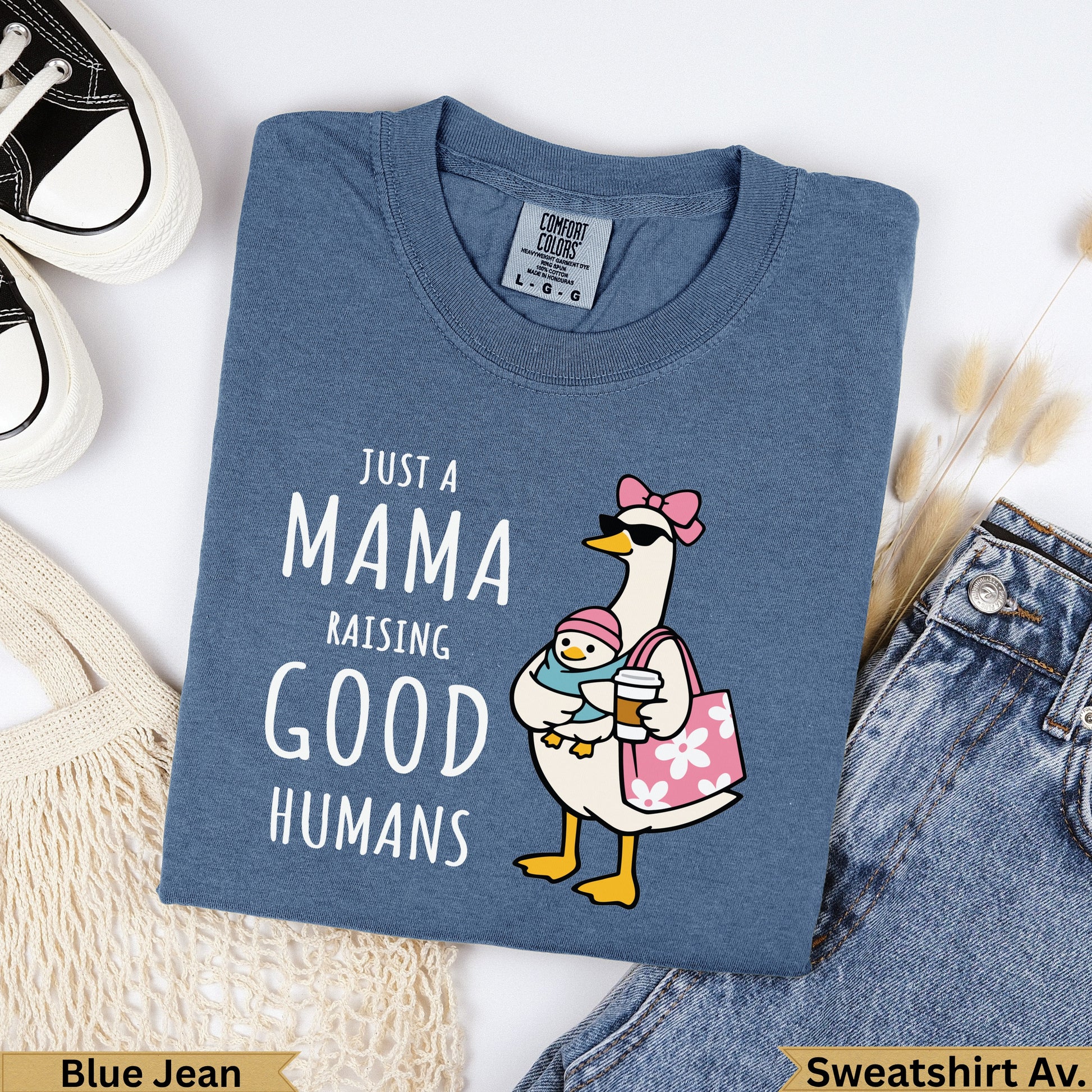 Blue t-shirt with "Just a Mama Raising Good Humans" graphic featuring a goose holding coffee.