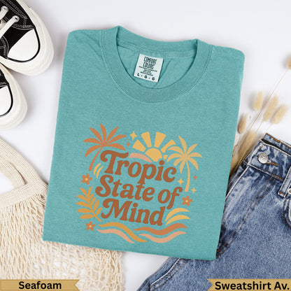 Teal "Tropic State of Mind" graphic sweatshirt on a flat lay with jeans.