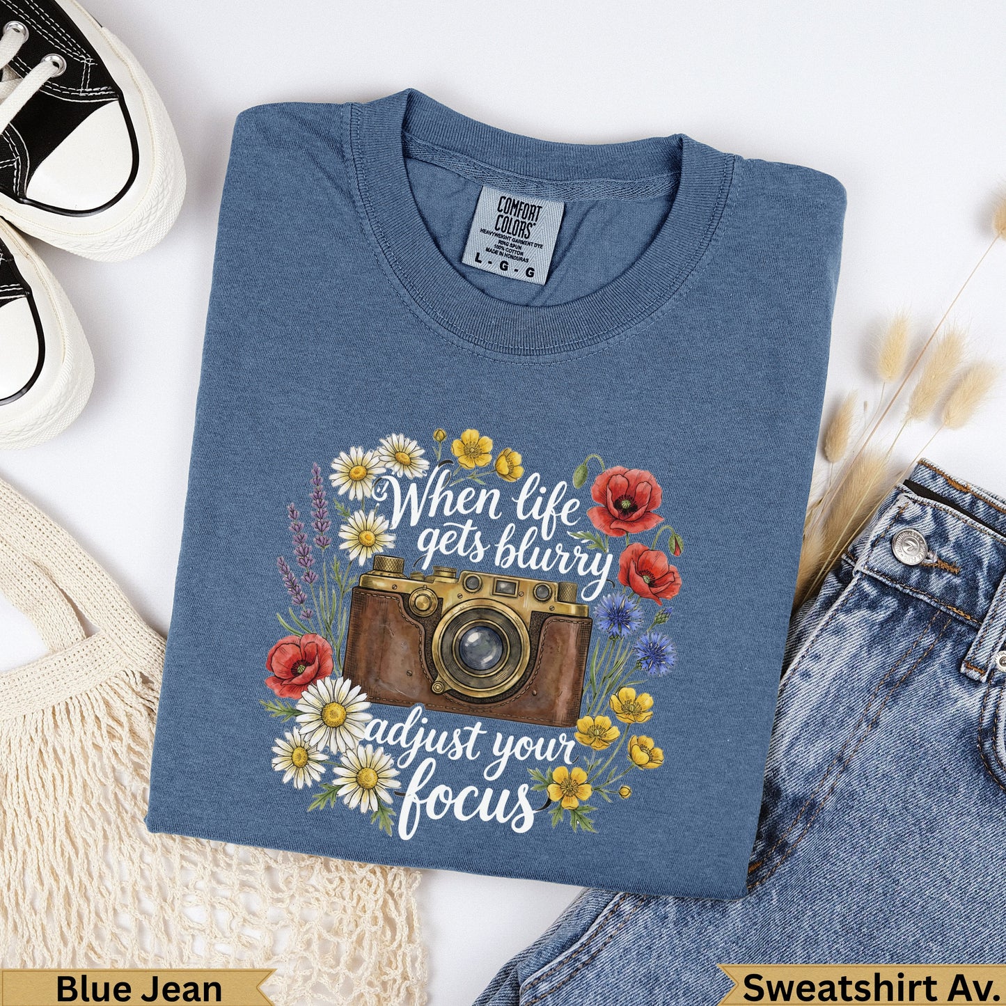 Blue t-shirt with vintage camera and floral graphic, "When life gets blurry adjust your focus".