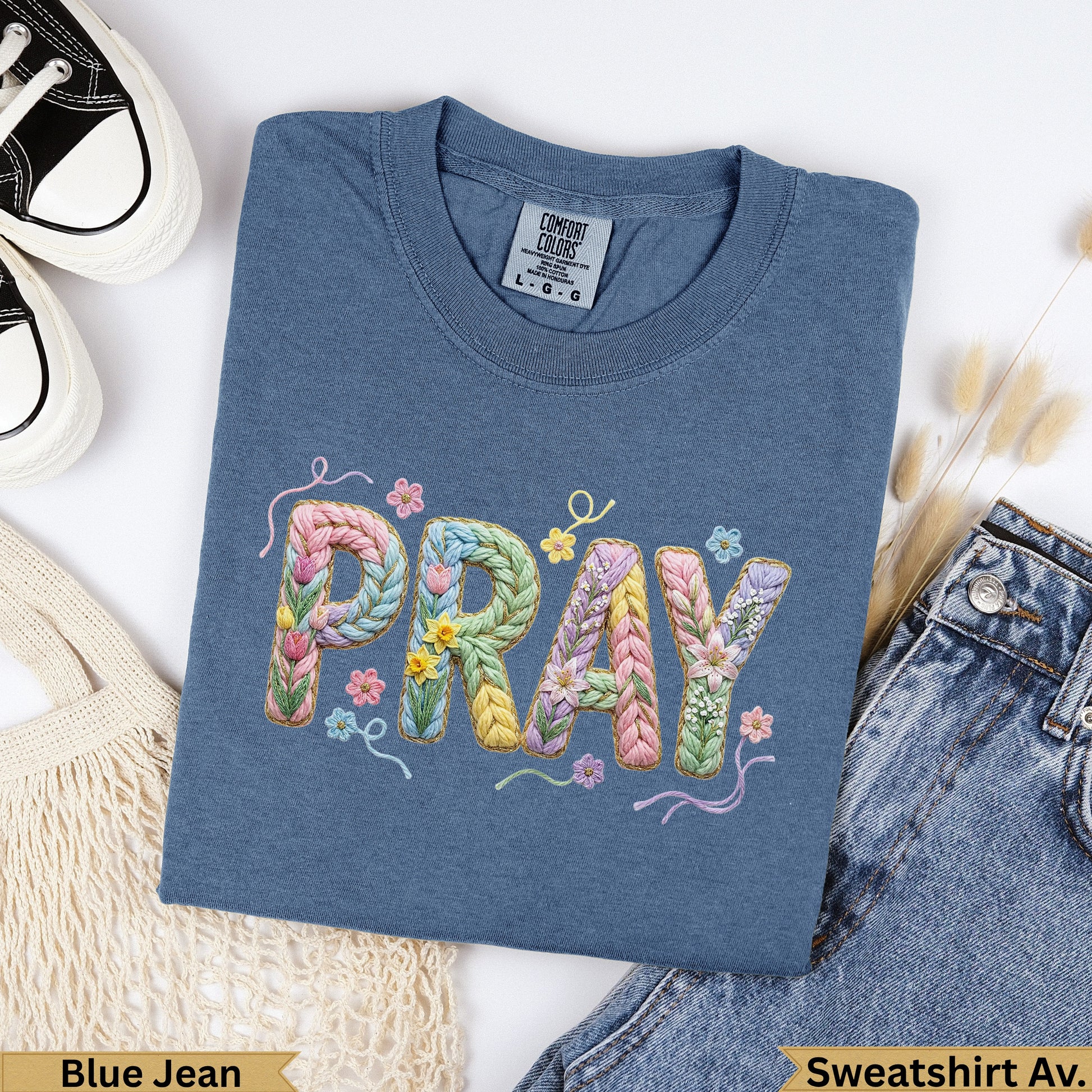 Blue Jean Comfort Colors t-shirt with "PRAY" embroidered in pastel yarn.