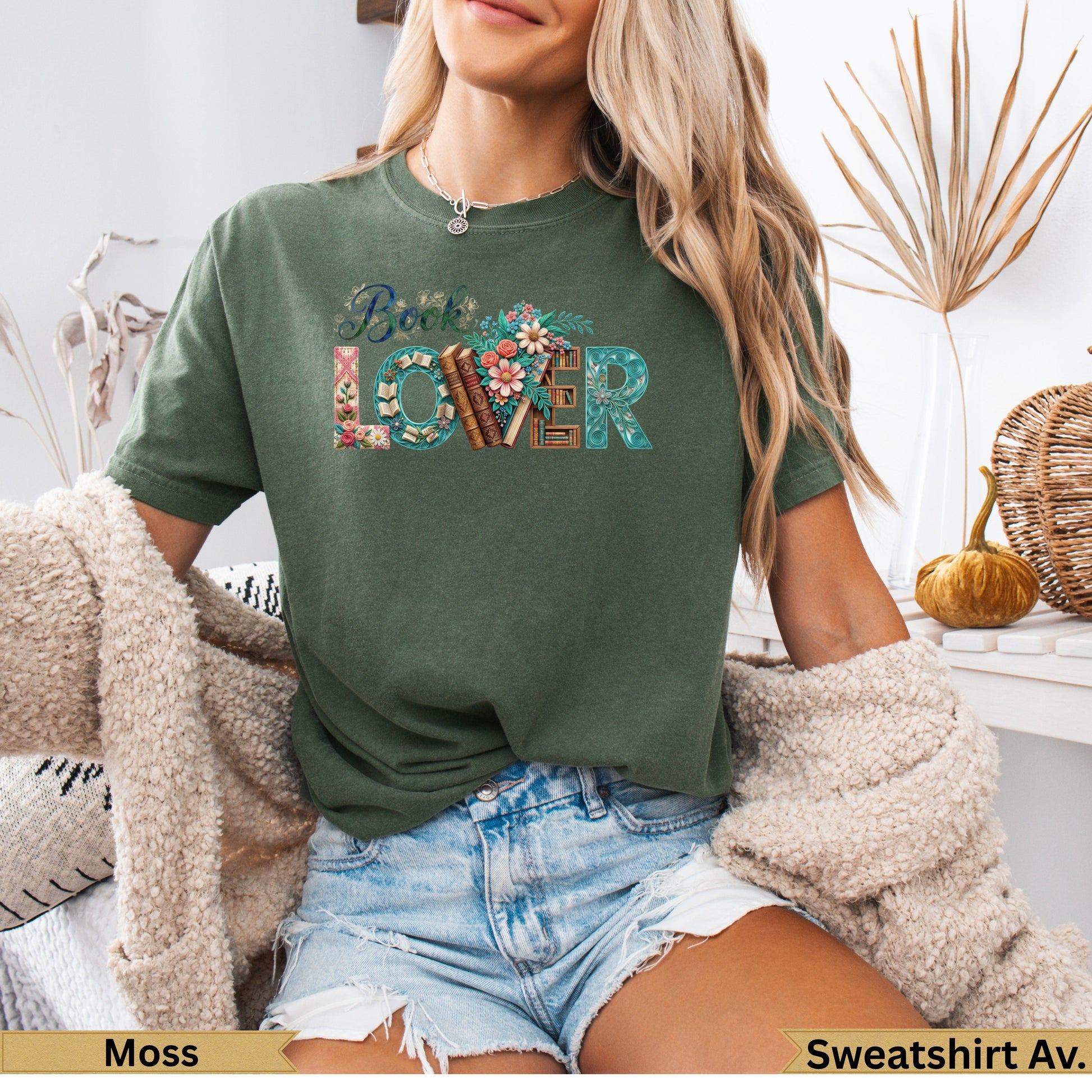 Green t-shirt with floral "Book Lover" text, worn by a person.