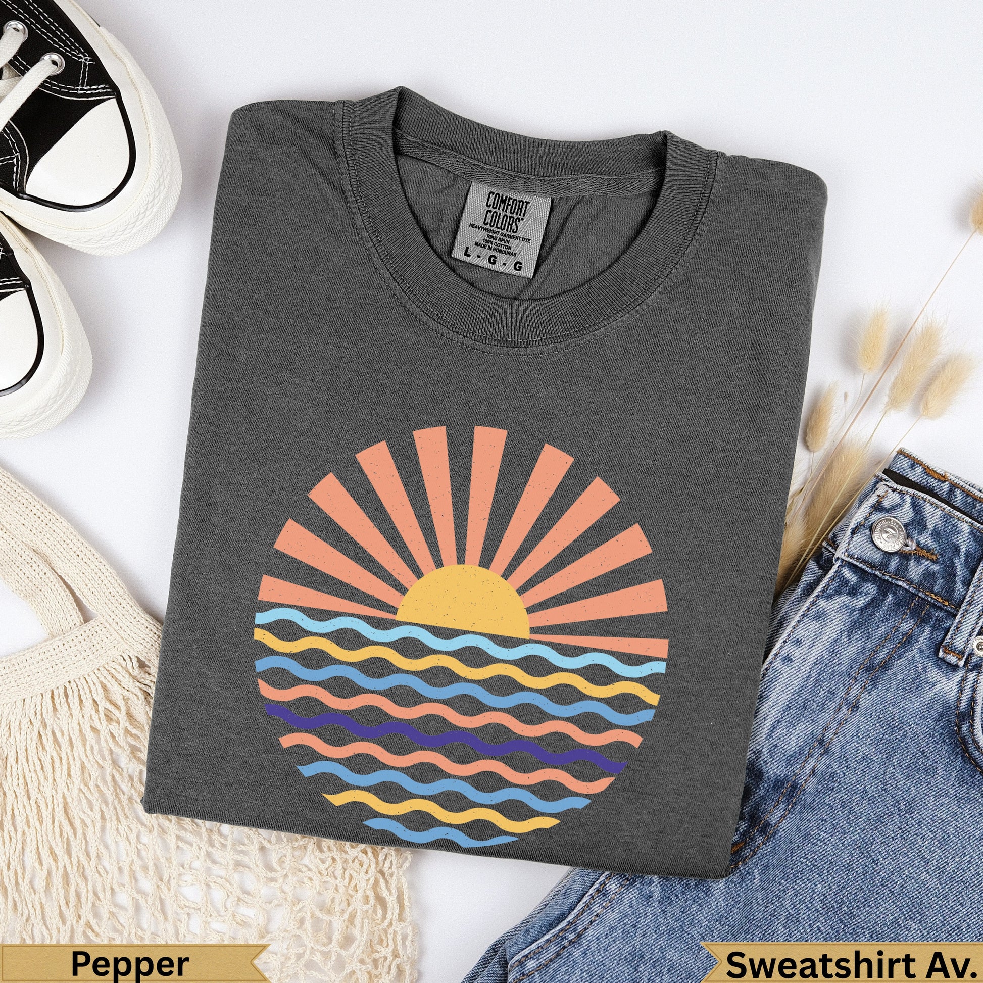Dark grey Comfort Colors t-shirt with a sunset over wavy water graphic.