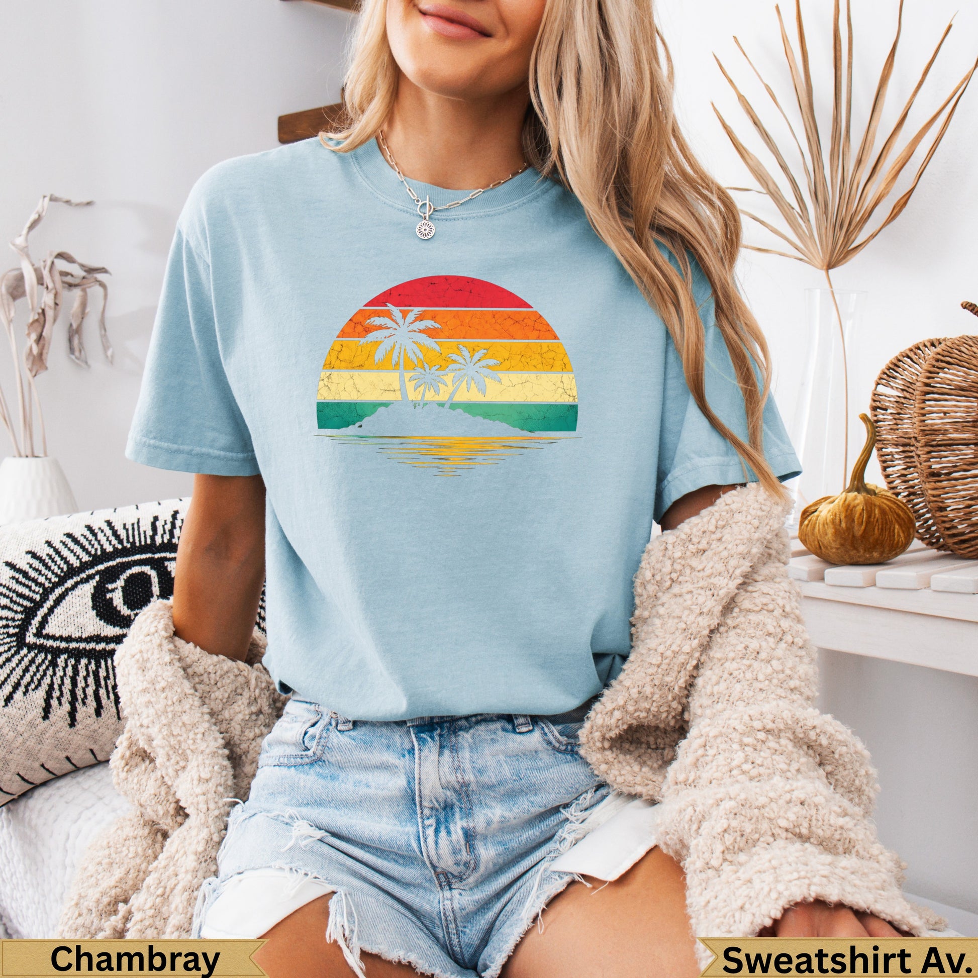 Light blue t-shirt with a retro sunset beach graphic and text.